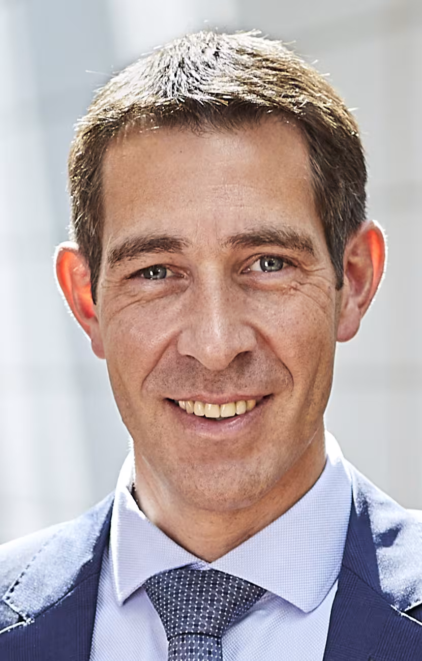 Portrait photo of Klaus Blaum. Front view of a man smiling at the viewer. He is not wearing glasses and has short brown hair.